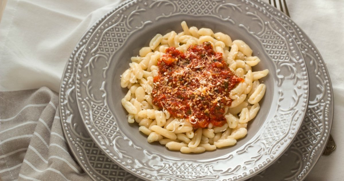 Pasta a forma di cuore con la parola amore su un piatto.